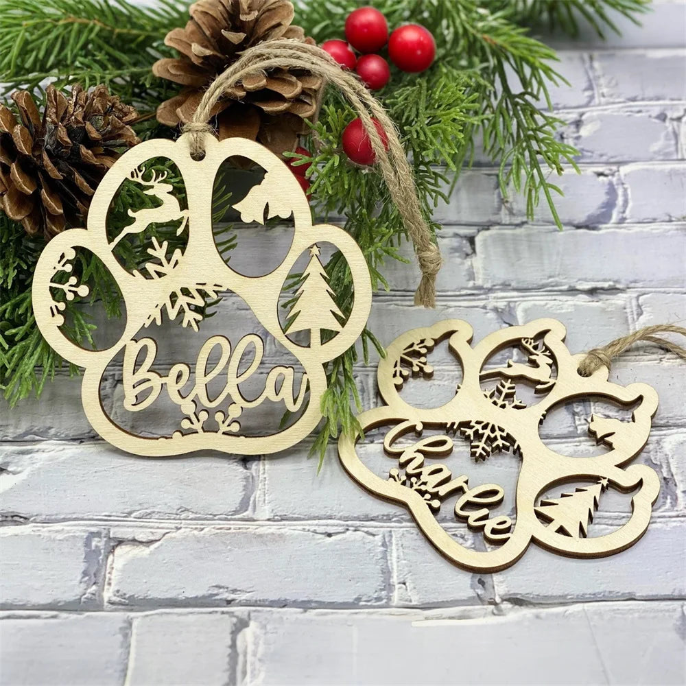 Wooden paw-shaped ornaments with engraved designs and names, hanging against a brick wall with greenery.
