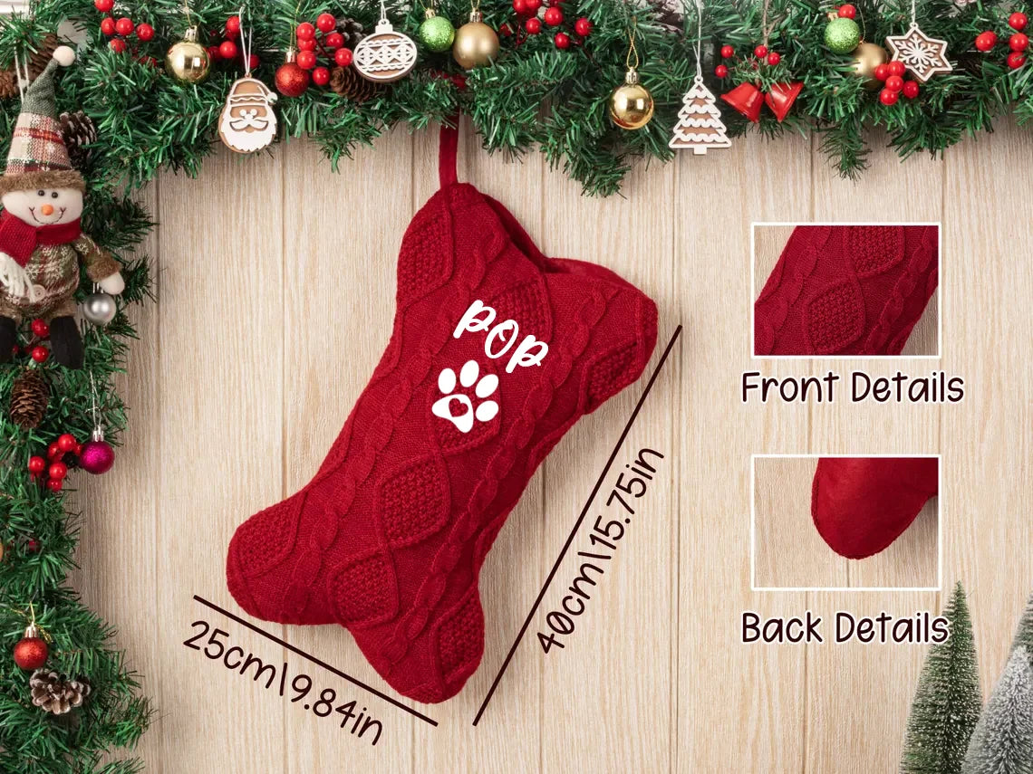 Red knitted Christmas stocking with paw print design, measurements, and close-up details on a wooden surface with festive decorations.